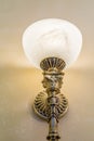 Brass sconce with lighting bulb on white wall Royalty Free Stock Photo