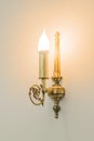 Brass sconce with lighting bulb on white wall Royalty Free Stock Photo