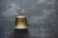 brass ships bell against grey metal wall