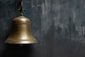 brass ships bell against grey metal wall