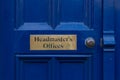 A brass sign reading Headmasters offices on a old blue door with a brass handle Royalty Free Stock Photo