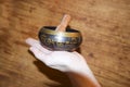 Brass singing Tibetan spiritual bowl on wooden background heal