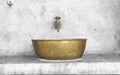 Brass sink and faucet on cement wall