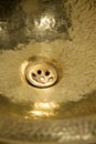 Detail of yellow brass round sink. Golden sink in retro style. Antique sink for home. Macro shooting.