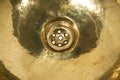 Detail of yellow brass round sink. Golden sink in retro style. Antique sink for home. Macro shooting. Royalty Free Stock Photo