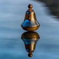 Brass spinning top reflecting on a still surface. A study in balance and symmetry. Royalty Free Stock Photo