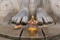 Brass statue infront of a gigiantic monolithic statue of Bahubali, also known as Gomateshwara, Vindhyagiri Hill, Shravanbelgola