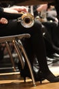 Brass trumpet on lap of girl in black dress, tights, and kitten heel shoes Royalty Free Stock Photo