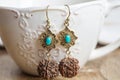 Turquoise stone Indian seed earrings on white cup background