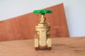 Brass valve with green knob in a factory plumber on wooden floo Royalty Free Stock Photo