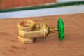 Brass valve with green knob in a factory plumber on wooden floo Royalty Free Stock Photo