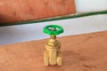 Brass valve with green knob in a factory plumber on wooden floo Royalty Free Stock Photo