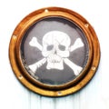 Brass vintage porthole with pirate flag Royalty Free Stock Photo