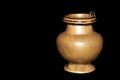 Brass water pot for worship on the black background
