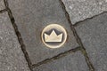 Bratislava, Slovakia - 19 April 2012: Crown-shaped tile on the ground as symbol of Coronation Trail. Brass crown marker in