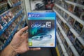 Man holding Project Cars 2 videogame on Sony Playstation 4 console in store