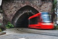 Red city tram drives from the tunnel under the castle hill. Brat