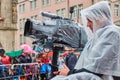 Team of a television station with waterproof packed camera equipment during video recordings of the carnival procession