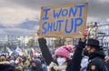 Young female demonstrator holds up a placard with the inscription