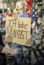 Blonde woman with ponytail hairstyle and a big poster saying she is afraid at the demonstration against climate change