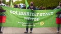 German green party poster with inscription: solidarity instead of agitation, demonstrators with face masks