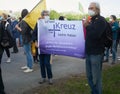 Older demonstrators with gray hair hold a protest poster of the Protestant Church of Germany against right-wing extremism