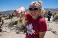 Brave adult female holds a thorn from a jumping Cholla Cactus in Joshua Tree National Park Royalty Free Stock Photo