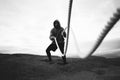 Brave athlete wearing sportswear doing intens workout using battle ropes on outdoor Royalty Free Stock Photo