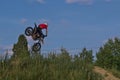 A brave biker jumps very high on a motorcycle and performs a stunt.