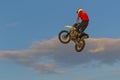 A brave biker jumps very high on a motorcycle and performs a stunt.