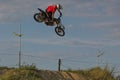 A brave biker jumps very high on a motorcycle and performs a stunt.