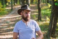 Brave cowboy. camping and hiking. mature male with brutal look. Bearded man in cowboy hat walk in park outdoor. man Royalty Free Stock Photo