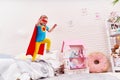 Brave cute little girl jumps out of bed, imagining flight Royalty Free Stock Photo