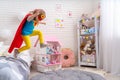 Brave cute little girl jumps out of bed, imagining flight Royalty Free Stock Photo