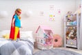 Brave cute little girl wants to jump out of bed, imagining flight