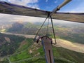 Brave extreme hang glider pilot flies high over valley with rive
