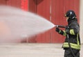 brave firefighter extinguishing a car fire using a special white