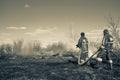 A brave firefighter puts out a grass fire in the villages close to the metropolis with the help of a water hydrant Royalty Free Stock Photo