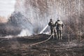A brave firefighter puts out a grass fire in the villages close to the metropolis with the help of a water hydrant