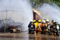 Brave firefighter using extinguisher and water from hose for fire fighting, Firefighter spraying high pressure water to fire,