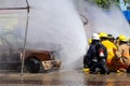 Brave firefighter using extinguisher and water from hose for fire fighting, Firefighter spraying high pressure water to fire,
