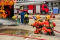 Brave firefighter using extinguisher and water from hose for fire fighting, Firefighter training with protective wear spraying