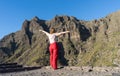 Brave Gorgeous Fashion Woman with red clothes and open arms, celebrating the achievement in from of the landscaped. Freedom