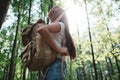 Hipster girl traveling alone and looking around in forest on outdoors wearing treveler backpack and hold location map in han