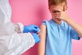 Brave kid boy get injection by doctor in suit