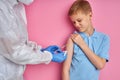 Brave kid boy get injection by doctor in suit