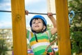 Brave little boy having fun at adventure park and smiling to camera wearing helmet.