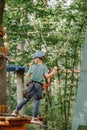 Brave little boy having fun at adventure park and smiling to camera wearing helmet. Scout practicing rappelling. Child - Royalty Free Stock Photo
