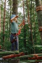 Brave little boy having fun at adventure park and smiling to camera wearing helmet. Scout practicing rappelling. Child - Royalty Free Stock Photo