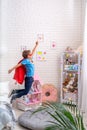 Brave little boy jumps out of bed, imagining flight. child plays superhero